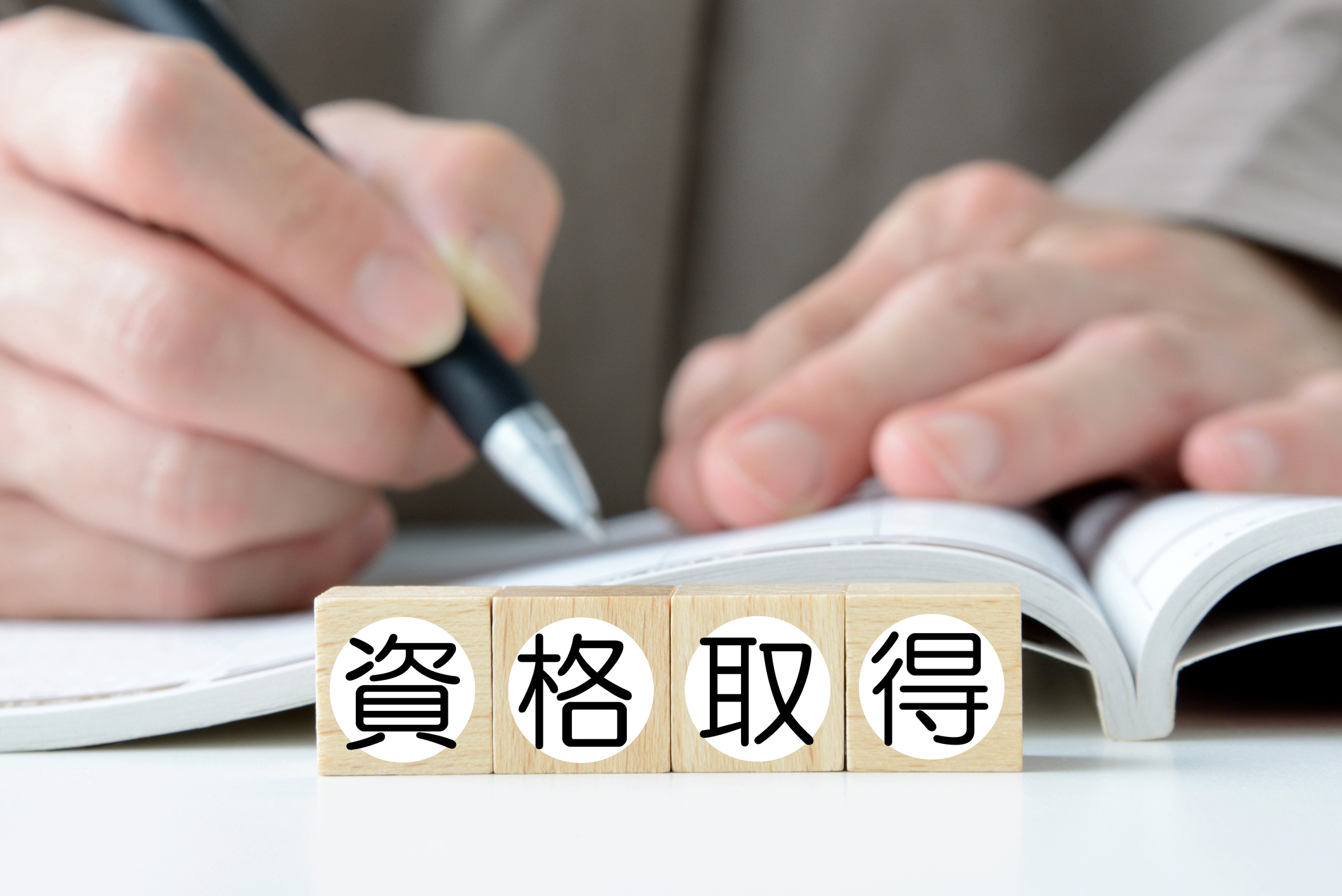 Wooden blocks with getting qualified word in Japanese and studying person
